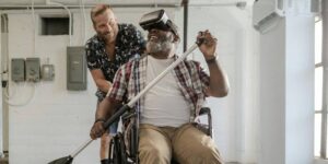 Jovem em atividade, usando VR com homem cadeirante
