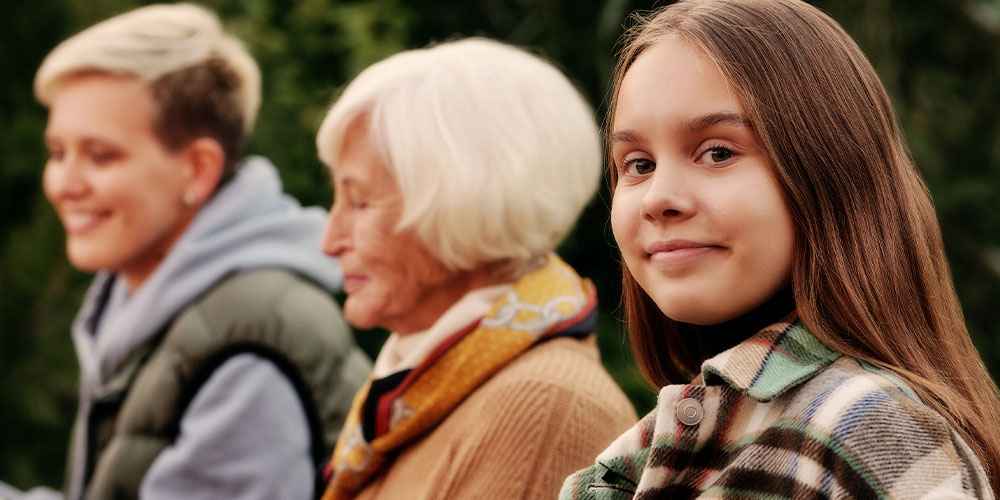 menina com avós e mãe ao fundo